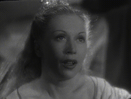 a black and white gif of a woman looking down, a tear running down her face and onto an open hand, where the tear is now a diamond