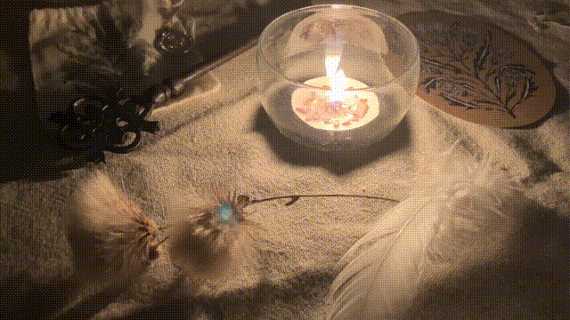 a lit candle surrounded by two thistles on one stem, a key, a feather, etc. the flame flickers around slightly but stays steady